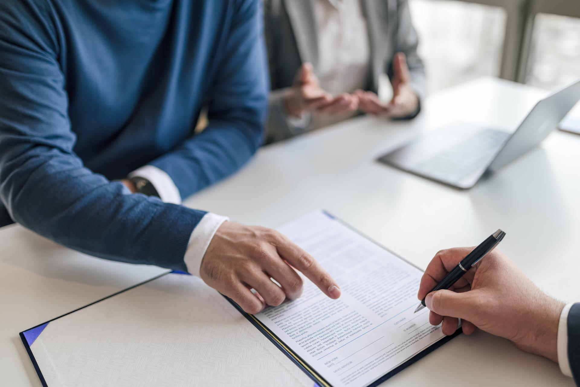 Business partners sealing successful deal with contract at desk in office